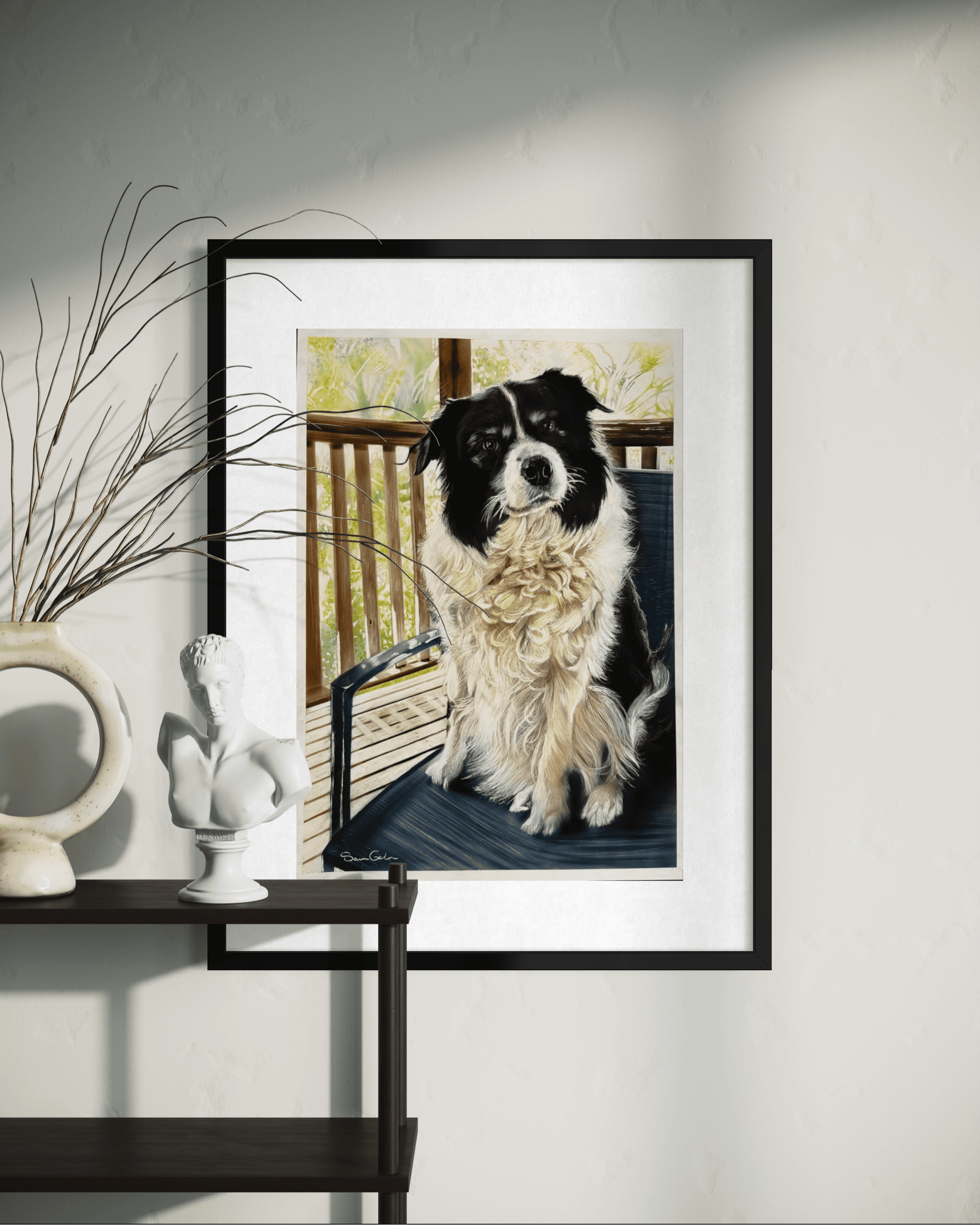 Framed painting of a black and white dog on a porch, hanging above a shelf.