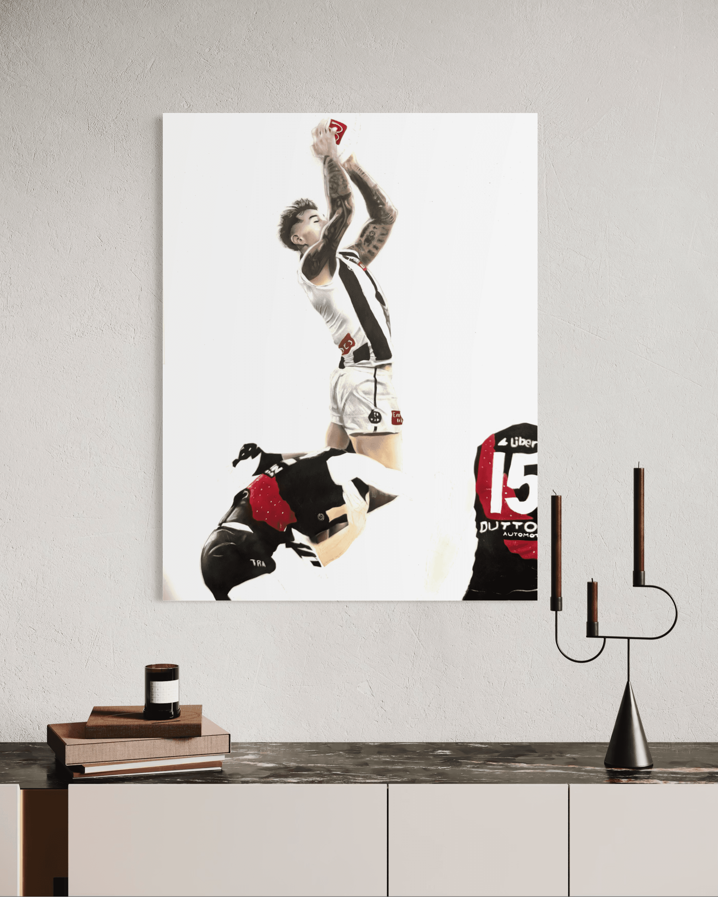 Wall art of a Collingwood AFL player taking a spectacular mark over an Essendon opponent.