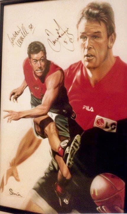 Signed artwork of Essendon AFL players James Hird and Andrew Lovett in team jerseys.